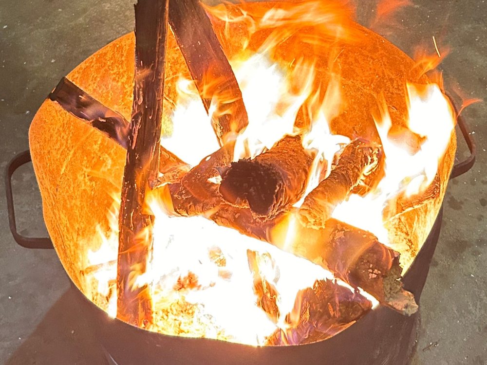 Custom steel fire pit with a roaring fire
